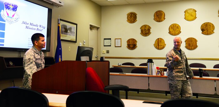 Staff Sgt. Guerddy Espinoza, First Term Airman Center NCO in charge, assists the vice commander with a presentation July 17, 2015, at Malmstrom Air Force Base, Mont. The NCOIC coordinates with the base staff agencies to schedule briefings to include a mission orientation briefing usually given by the base commander or vice commander. (U.S. Air Force photo/Airman 1st Class Magen M. Reeves)