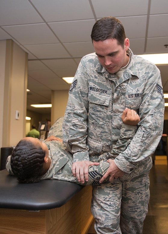 Staff Sgt. Jake Wielgosiek helps a patient with a shoulder injury July 28, 2015 at the 628th Medical Group physical therapy clinic.  On average, Wielgosiek sees 12 patients a day. (U.S. Air Force photo/ Thomas T. Charlton)