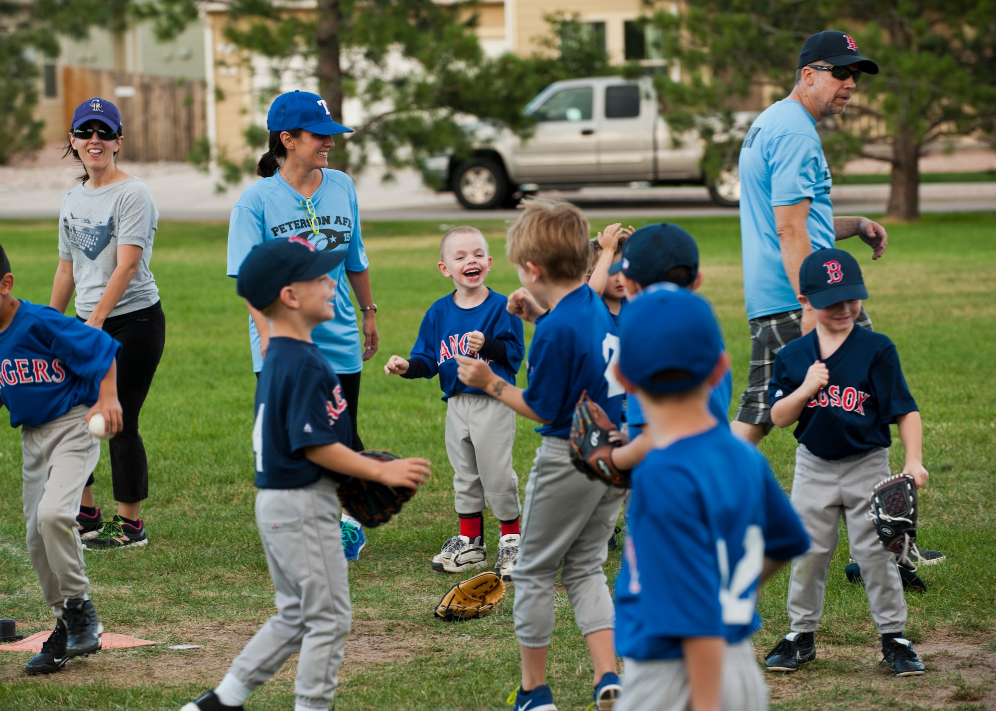 PETERSON AIR FORCE BASE, Colo. -- Brecken Levy (center), 6, is all smiles after high-fiving his teammates at the end of a t-ball game at Patriot Park, July 28, 2015. As a child with special needs, the inclusion and acceptance of everyone involved with the sports program at the R.P. Lee Youth Center makes him feel like just another player. Brecken’s favorite part of the program is just being another kid, hanging out and doing what kids do. (U.S. Air Force photo by Airman 1st Class Rose Gudex)