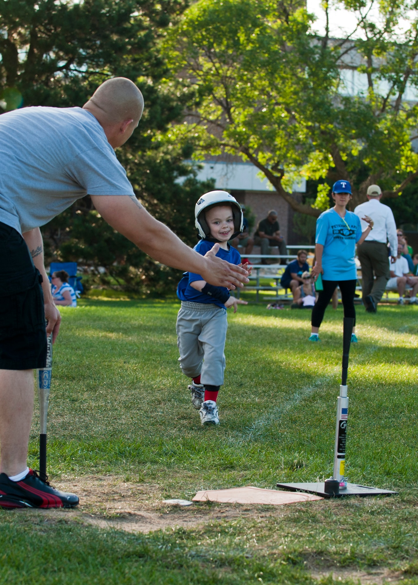 PETERSON AIR FORCE BASE, Colo. – Brecken Levy, 6, looks to a volunteer for a high five as he approaches home plate during a t-ball game at Patriot Park, July 28, 2015. As a child with special needs, the inclusion and acceptance of everyone involved with the sports program at the R.P. Lee Youth Center makes him feel like just another player. Brecken’s favorite part of the program is just being another kid, hanging out and doing what kids do. (U.S. Air Force photo by Airman 1st Class Rose Gudex)