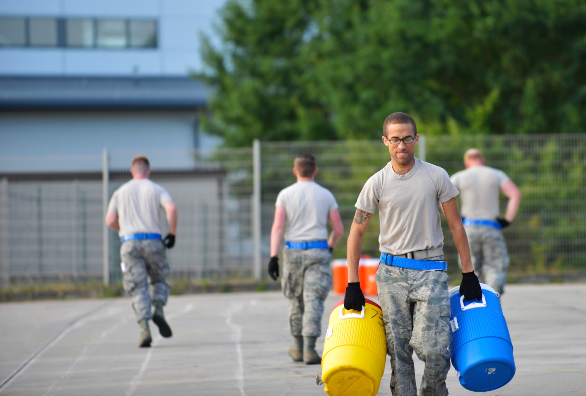 Staff Sgt. Ryan Evans, 721st Aerial Port Squadron passenger services specialist, carries water jugs during the obstacle course at the 2015 Ramstein Air Base Rodeo Aug. 1, 2015, at Ramstein Air Base, Germany. The rodeo is a skills competition and includes numerous events such as forklift operations, center of balance calculations, and cargo pallet buildup. (U.S. Air Force photo/Staff Sgt. Sharida Jackson)