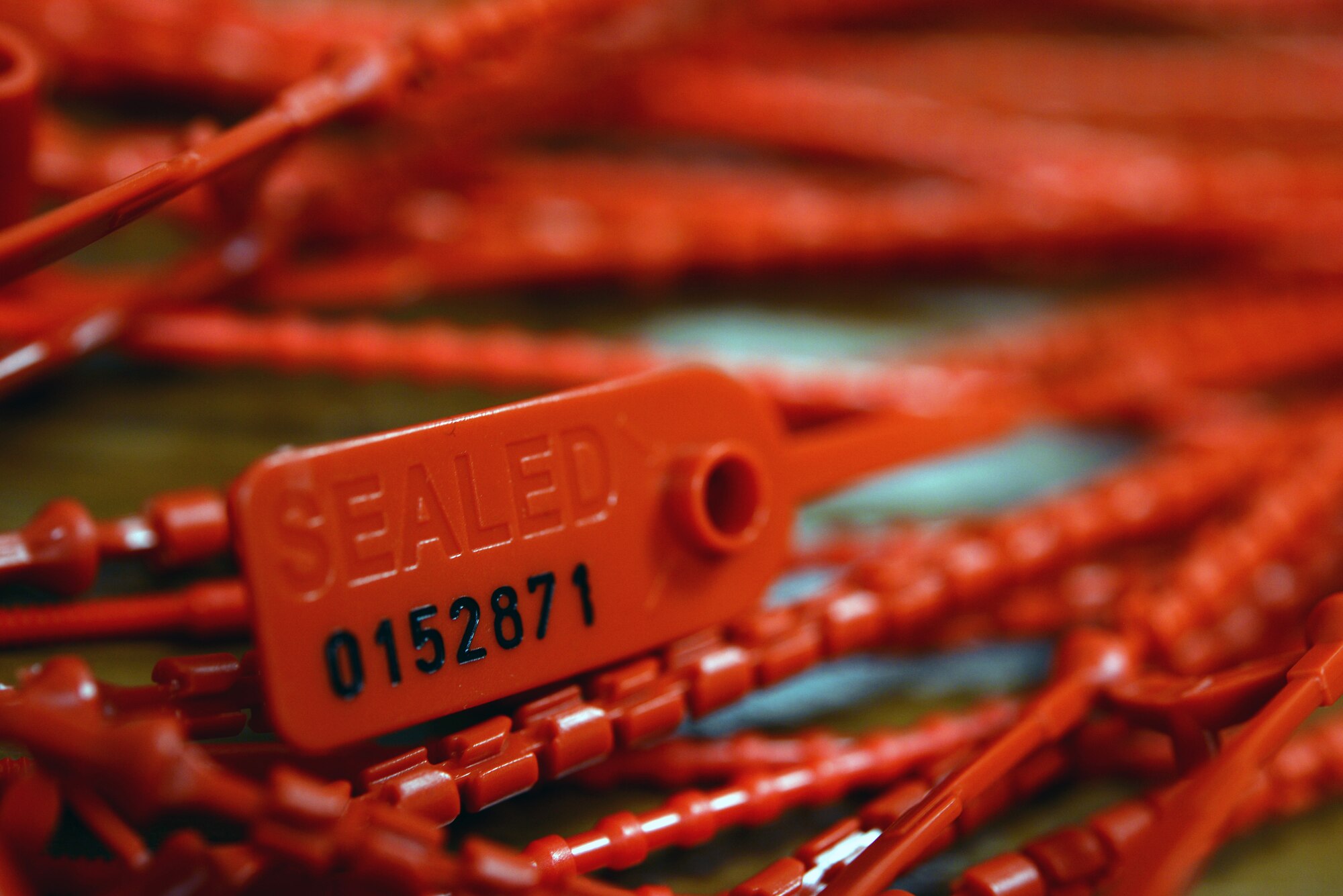 A seal for a communications kit sits in a pile July 16, 2015, on RAF Mildenhall, England. Airmen from the 100th Operations Support Squadron combat crew communications flight use these seals to ensure kits are secure and free from tampering. (U.S. Air Force photo by Senior Airman Christine Halan/Released)