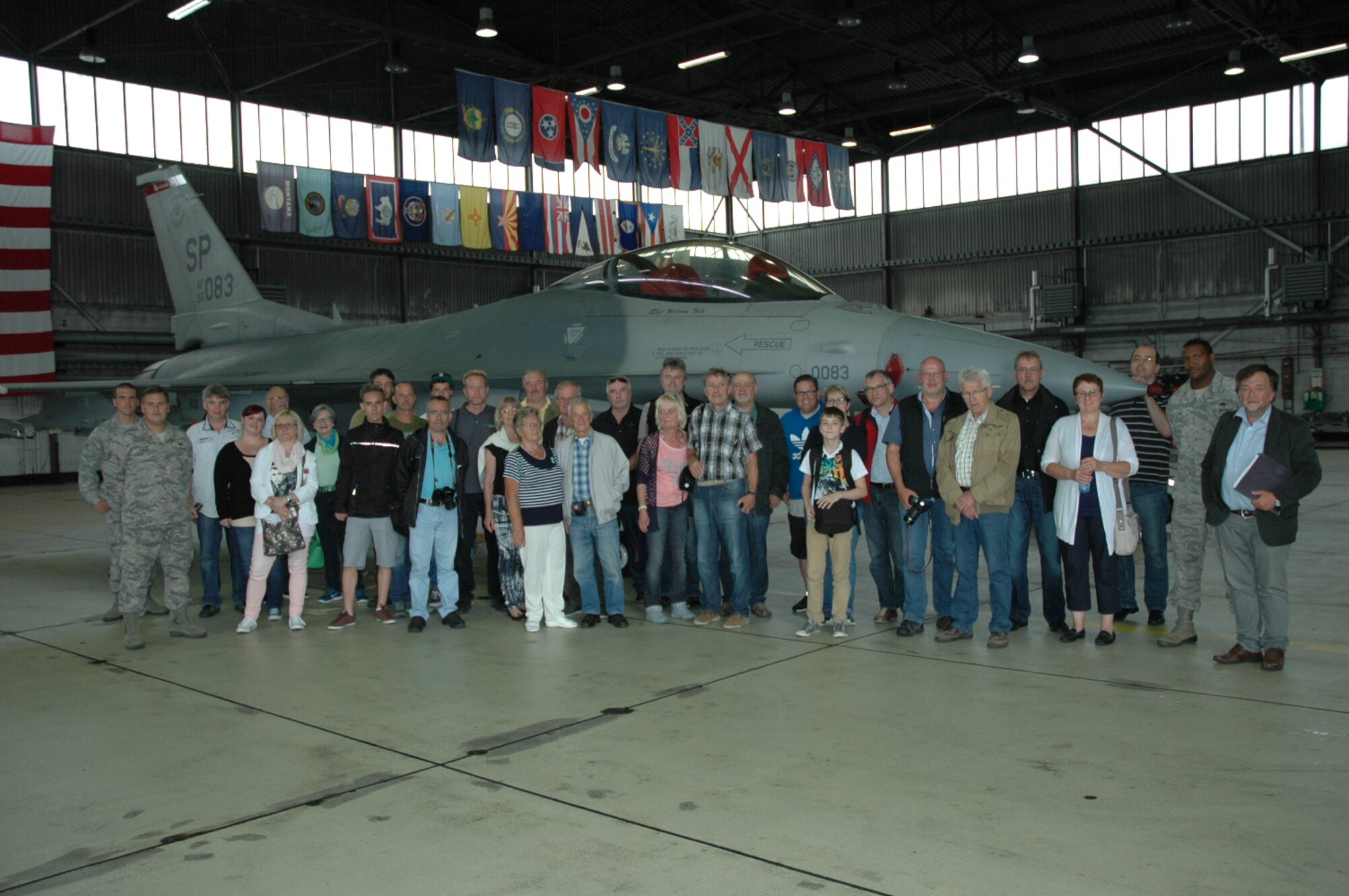 Members from the Freundeskreis der Luftwaffe e.V. Association pose with Airmen assigned to the 52nd Maintenance Group and their tour guides in front of an F-16 Fighting Falcon fighter aircraft during the association’s visit of Hangar One at Spangdahlem Air Base, Germany, July 13, 2015. The tour included sections of the 726th Air Mobility Squadron as well as sites from the 52nd Fighter Wing. (U.S. Air Force photo by Iris Reiff/Released)