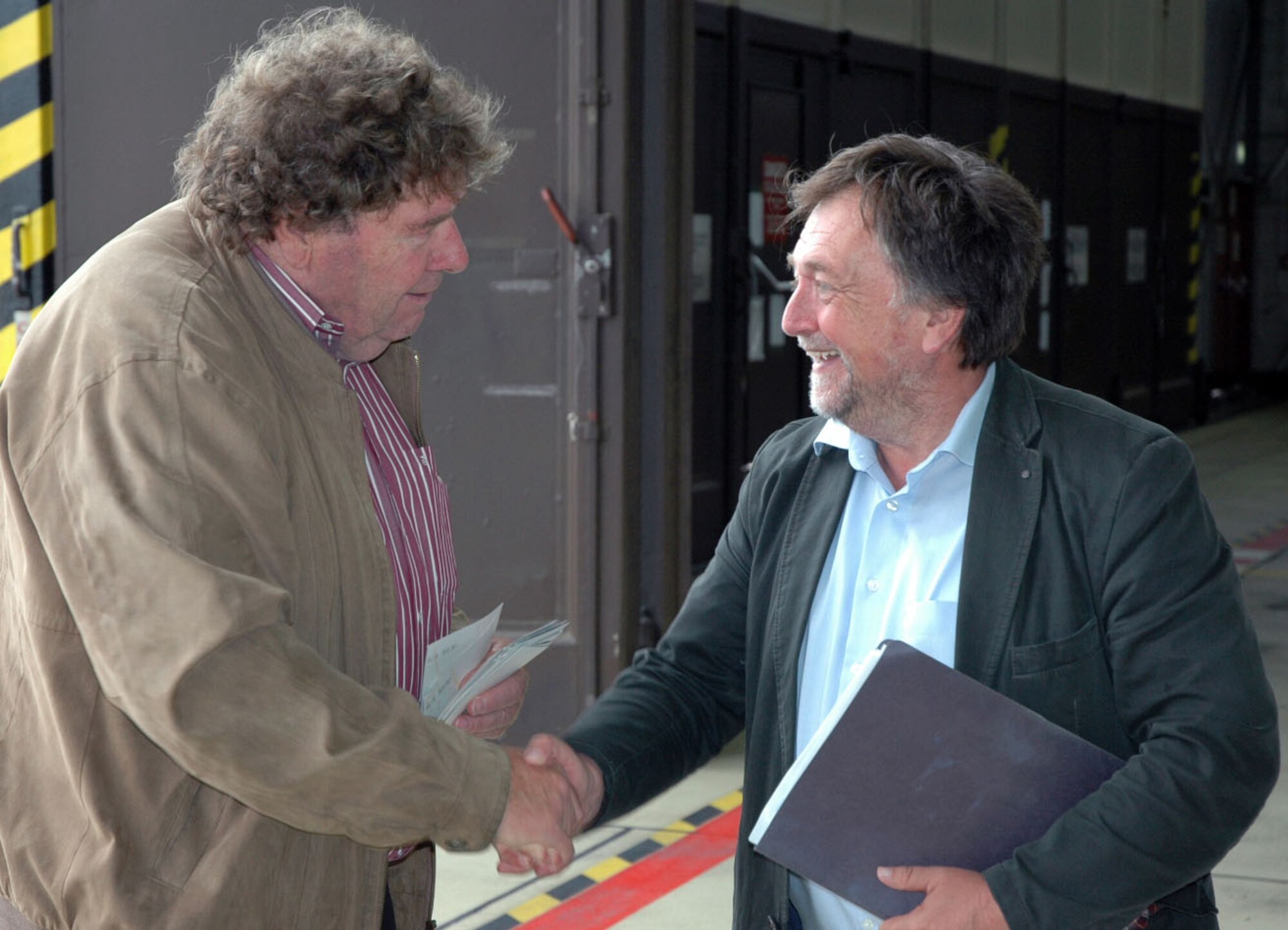 Hans Fries, a member of the Freundeskreis der Luftwaffe e.V. Association, shakes hands with Bernhard Schaefer, 52nd Fighter Wing community relations advisor, during the association’s tour of Spangdahlem Air Base, Germany, July 13, 2015. The tour included sections of the 726th Air Mobility Squadron as well as sites from the 52nd FW. (U.S. Air Force photo by Iris Reiff/Released) 