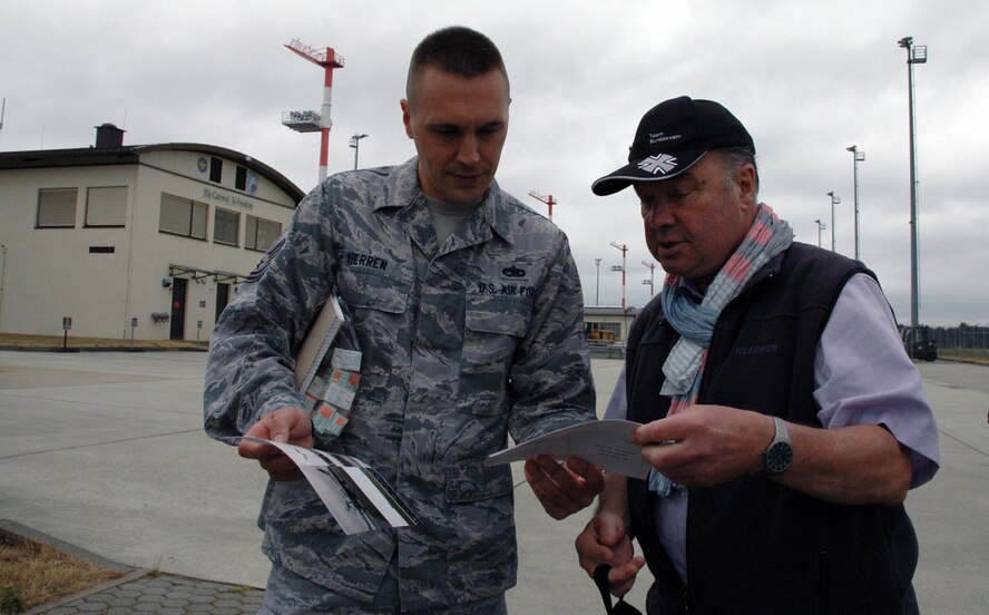 Werner Cordes, a member of the Freundeskreis der Luftwaffe e.V. Association, shows historical aircraft photos from past visits to U.S. Air Force Tech. Sgt. Robert Herren,  a 726th Air Mobility Squadron maintenance flight chief, during the association’s tour of Spangdahlem Air Base, Germany, July 13, 2015. The tour also included sites from the 52nd Fighter Wing. (U.S. Air Force photo by Iris Reiff/Released) 