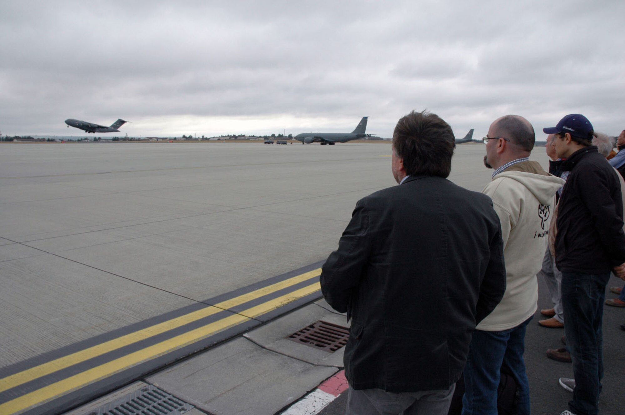 Members from the Freundeskreis der Luftwaffe e.V. Association and Bernhard Schaefer, a 52nd Fighter Wing Community Relations advisor, watch as a C-17 Cargo aircraft takes off from the flightline during the association’s tour of Spangdahlem Air Base, Germany, July 13, 2015.The tour included sections of the 726th Air Mobility Squadron as well as sites from the 52nd FW. (U.S. Air Force photo by Iris Reiff/Released)