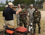 Jeff Welch, counter-improvised explosive device site lead, explains how a specific type of IED is triggered to senior leadership of Liberia’s military at the C-IED range at the Camp Grayling Joint Maneuver Training Center in Grayling, Michigan, Aug. 2, 2015.  Michigan and Liberia have been partners under the U.S. National Guard’s State Partnership Program since 2009. 