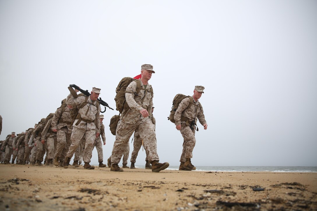 Colonel Paul P. Ryan (front left), the commanding officer of Headquarters and Service Battalion, U.S. Marine Forces Command, and Gunnery Sgt. John W. Hilderbrand (front right), the operations and training chief at the battalion,  lead the two-column formation during a beach hike, April 8, at Joint Expeditionary Base Little Creek-Fort Story, Virginia Beach, Va.