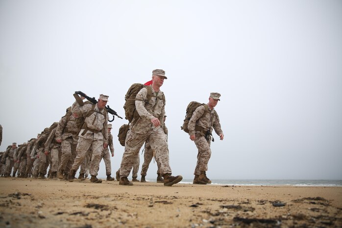 Colonel Paul P. Ryan (front left), the commanding officer of Headquarters and Service Battalion, U.S. Marine Forces Command, and Gunnery Sgt. John W. Hilderbrand (front right), the operations and training chief at the battalion,  lead the two-column formation during a beach hike, April 8, at Joint Expeditionary Base Little Creek-Fort Story, Virginia Beach, Va.