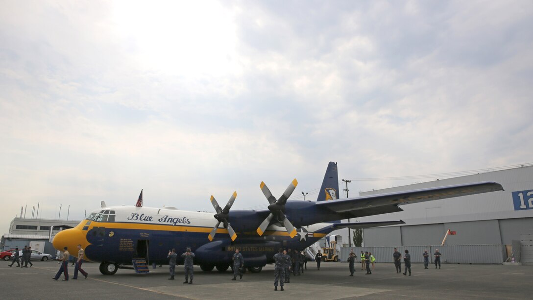 Two Marines with 1st Intelligence Battalion, I Marine Expeditionary Force Headquarters Group and sailors take pictures of the Blue Angels C-130T Hercules, known as “Fat Albert,” prior to flying as the aircraft’s passengers in Seattle, August 2. Blue Angels pilots and crew members accepted active-duty service members as passengers for the Boeing Seafair Air Show August 1-2, 2015.