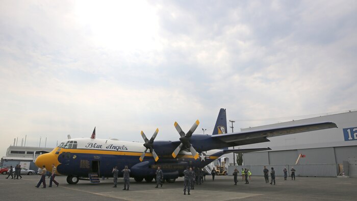 Two Marines with 1st Intelligence Battalion, I Marine Expeditionary Force Headquarters Group and sailors take pictures of the Blue Angels C-130T Hercules, known as “Fat Albert,” prior to flying as the aircraft’s passengers in Seattle, August 2. Blue Angels pilots and crew members accepted active-duty service members as passengers for the Boeing Seafair Air Show August 1-2, 2015.