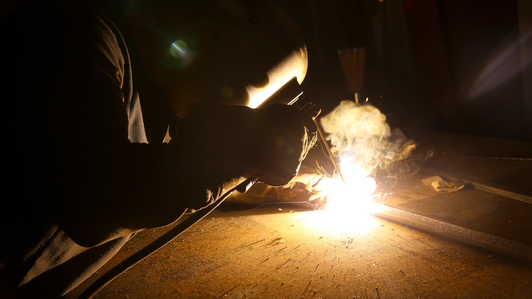 U.S. Marine Sgt. Arnet Moore, a welder with the Logistics Combat Element, Special Purpose Air-Ground Task Force-Crisis Response-Central Command, welds a piece of metal for a project in Southwest Asia, July 19, 2015.