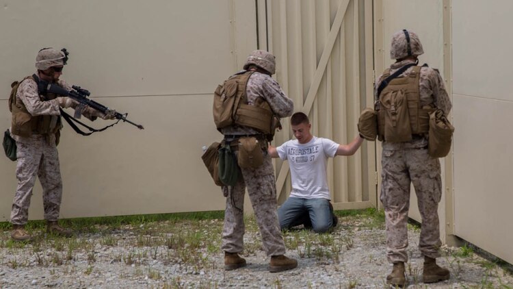 Three Marine with Bravo Company, 2nd Law Enforcement Battalion, II Marine Expeditionary Force Headquarters Group, apprehend an intruder during a week-long exercise at GSRA FOB aboard Camp Lejeune, North Carolina, August 5, 2015. During the exercise, the Marines were put into situations in which they would have to control various scenarios and eliminate threats to valuable assets.