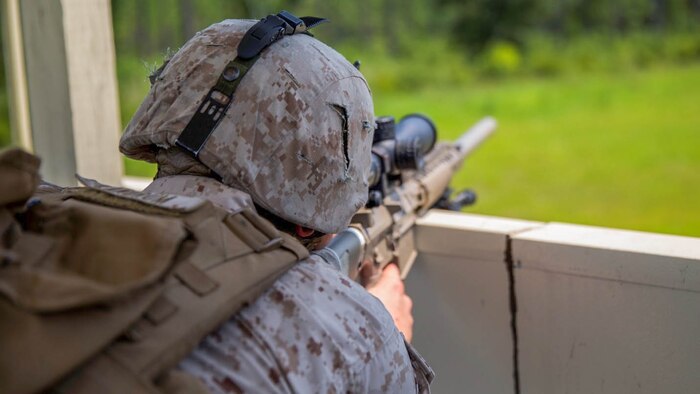 Lance Cpl. Hunter Ladrum, a designated marksman with Bravo Company, 2nd Law Enforcement Battalion, II Marine Expeditionary Force Headquarters Group, sights in on possible threats during a week-long exercise at GSRA FOB aboard Camp Lejeune, North Carolina, August 5, 2015. The company conducted the training from August 4-7, in which they simulated the protection of a submarine during fueling operations.
