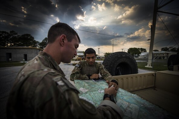 Senior Airman William Manis and Airman 1st Class Ricardo Maggin, 1st Special Operations Security Forces Squadron deployed aircraft ground response element team members, plan an operation during a task force exercise on Eglin Range Complex, Fla., July 28, 2015.  Exercise scenarios included downed aircraft site security and armed escort. Through the scenarios, DAGRE was able to accomplish multiple training objectives including close quarters combat, small unit tactics, flight deck denial, fly away security, close air support, casualty evacuation and more. (U.S. Air Force photo by Senior Airman Christopher Callaway)