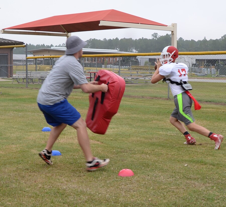Adam Crosby, special teams’ coordinator quarterback and receiver coach, Sherwood Christian Academy, Albany, Ga., recently practices with a student during a weeklong training camp held at Marine Corps Logistics Base Albany.