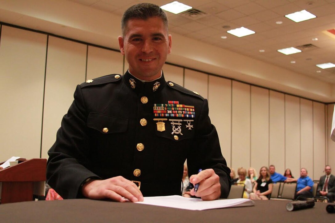 U.S. Marine Corps Maj. Gabriel L. Diana, Commanding Officer of Recruiting Station Charleston, West Virginia., and a native of Columbus, Ohio, poses after signing the Common Ground Compact July 29, 2015, at the Waterfront Convention Center in Morgantown, West Virginia.  The compact is a combined effort between the Department of Education and the military to reduce the high school dropout rate and ensure students across West Virginia are career and college ready. (U.S. Marine Corps photo by Sgt. Caitlin Brink/Released)