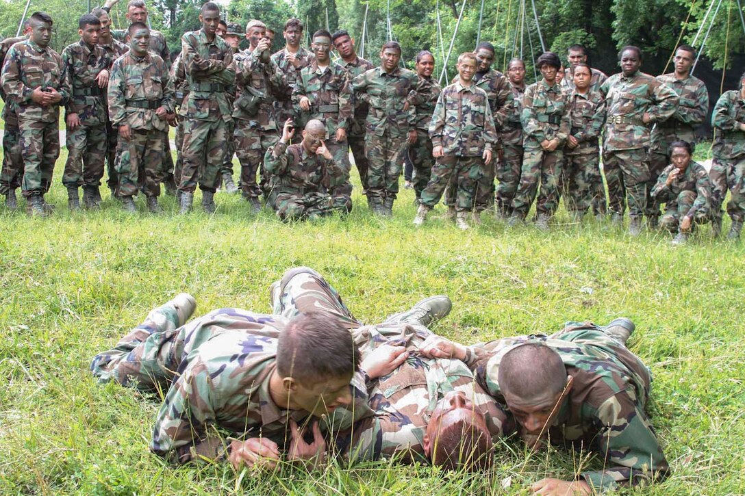 Air Force Junior Reserve Officer Training Corps cadets demonstrate how to properly drag a casualty while under enemy fire during the AFJROTC Chantilly Academy Cadet Leadership Course on Joint Base Andrews Naval Air Facility Washington, June 25, 2015. On this tactical training day portion of the course, Marine Corps recruiters in Chantilly, Virginia provided training in low crawl, high crawl, camouflage techniques, proper use of camouflage face paint, basic squad tactics and buddy carrying. (U.S. Marine Corps photo by Sgt. Anthony J. Kirby/Released)