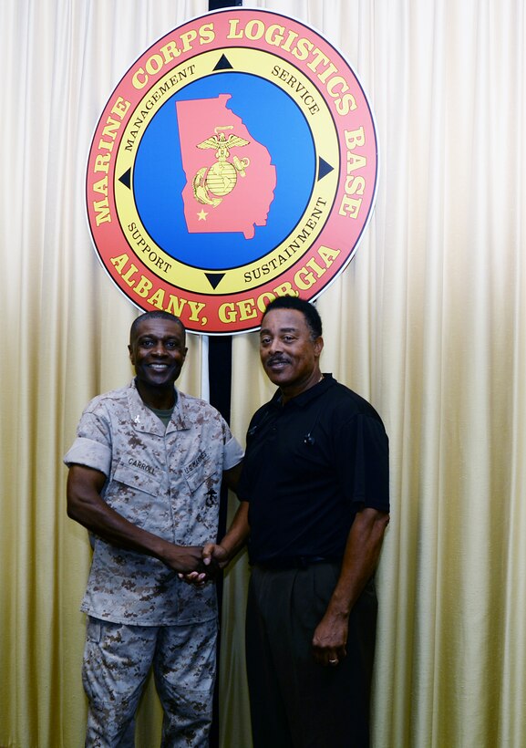 Donny Green, (right) transportation specialist, Marine Corps Logistics Base Albany, receives a coin from Col. James C. Carroll III, commanding officer, Marine Corps Logistics Base Albany, for his efforts to keep the community safe. Green observed uncovered manholes in Holloway Park, Albany, Ga., and reported the unsafe condition to the City of Albany’s Recreation and Parks Department. 