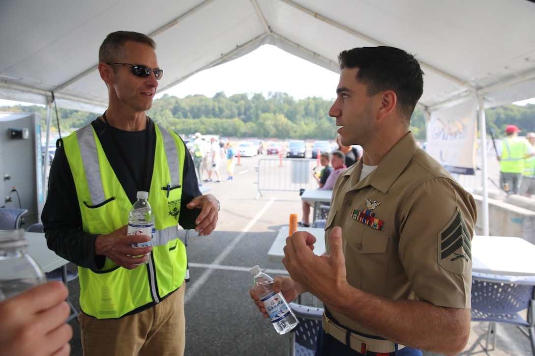 Sgt. Carmen Zangari, a counterintelligence student with 1st Intelligence Battalion, I Marine Expeditionary Force (MEF), and a Sunbury, Pennsylvania native, speaks with a Seafair volunteer at the Boeing Seafair Air Show in Seattle, August 2. Zangari rode in a C-130T Hercules, known as “Fat Albert,” with the Navy flight demonstration squadron, the Blue Angels, during the air show. (U.S. Marine Corps photo by Sgt. Lillian Stephens/Released)