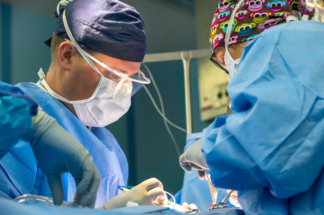 U.S. Navy Lt. James Wallace, left, and U.S. Navy Lt. Cmdr. Kristen Stevens perform hernia repair surgery on a Filipino patient aboard the hospital ship USNS Mercy during Pacific Partnership 2015 in Roxas City, Philippines, July 25, 2015.