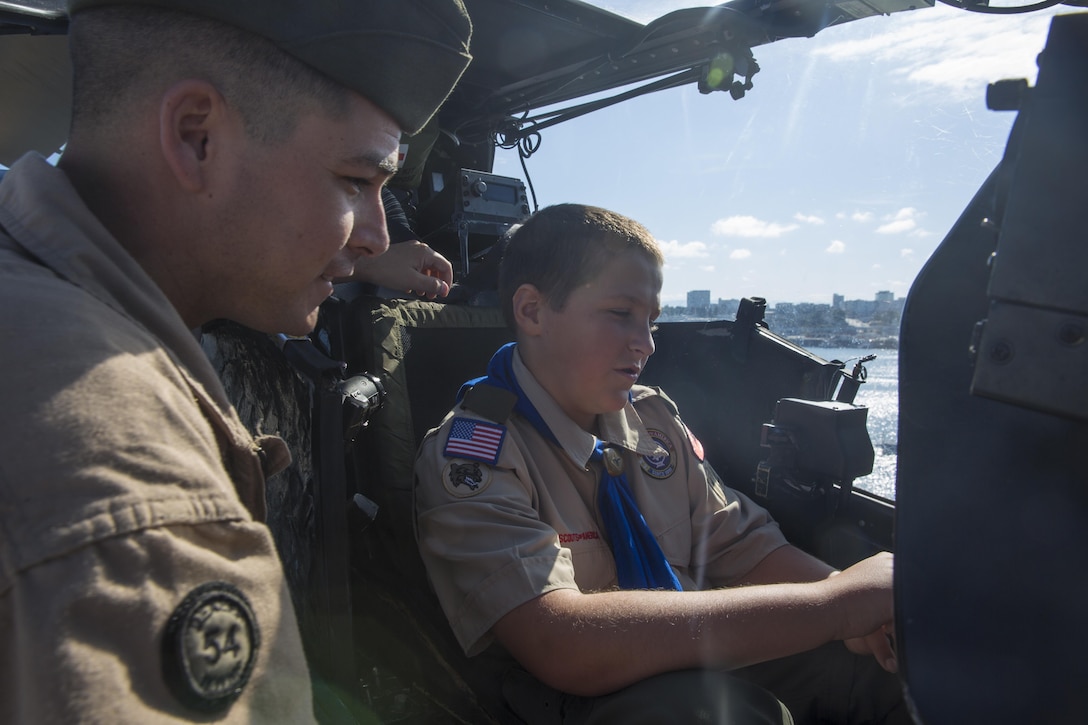 Sgt. John Moreau, an airframes mechanic with Marine Light Attack Helicopter Training Squadron (HMLAT) 303, and a San Angelo, Texas, native, oversees an AH-1W Super Cobra static display as a Boy Scout sits in the aircraft’s cockpit in Seattle, July 28. Members of the Boy Scouts of America toured static displays aboard the USS Boxer as it completed its journey Seattle to participate in Sea Fair Fleet Week.