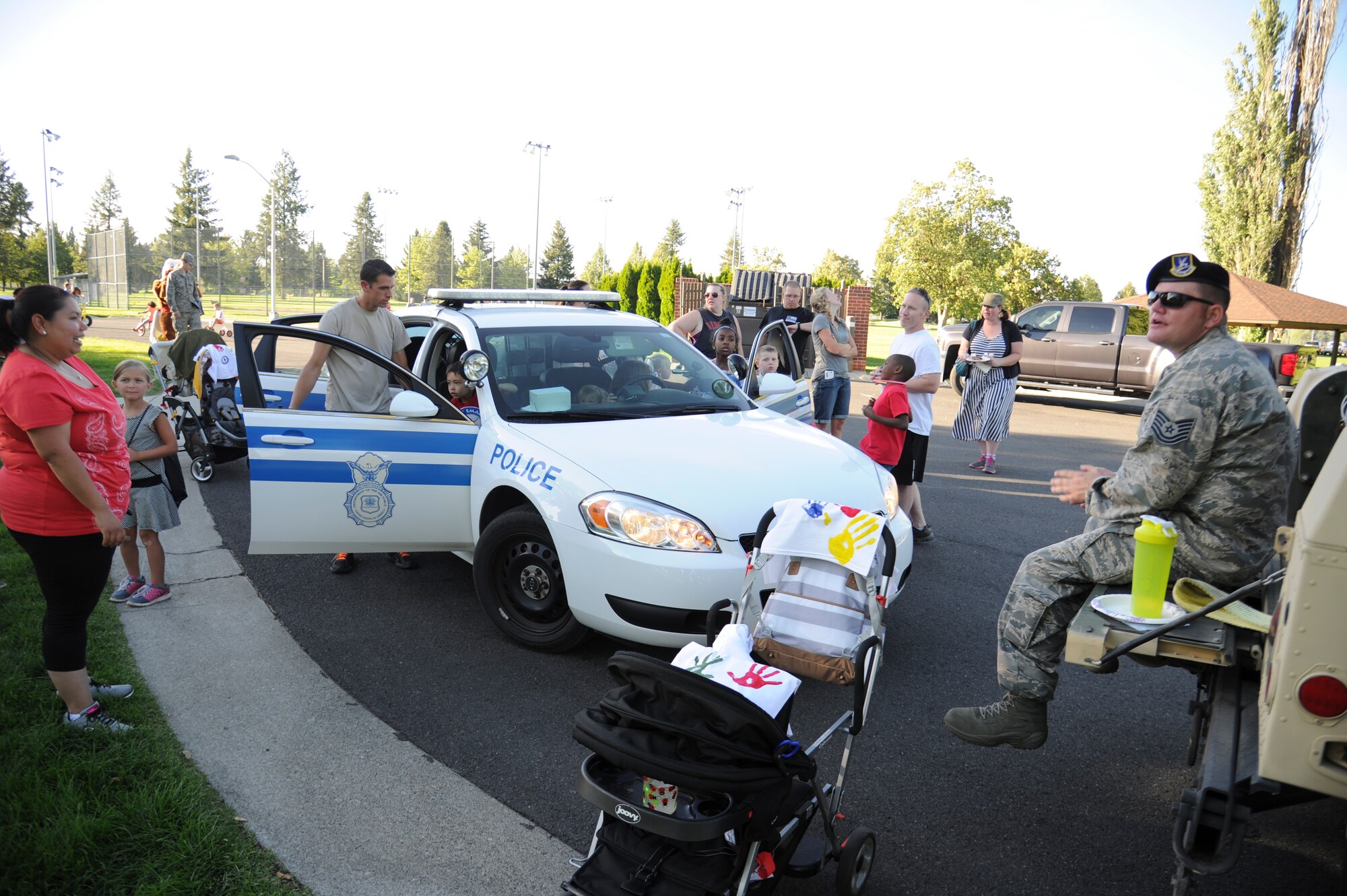 Members of Team Fairchild overlook a 92nd Security Forces Squadron patrol car during the National Night Out event held at Miller Park Aug. 4, 2015, at Fairchild Air Force Base, Wash. There were a variety of displays and stations for attendees to examine and learn about. (U.S. Air Force photo/Airman 1st Class Nicolo J. Daniello)