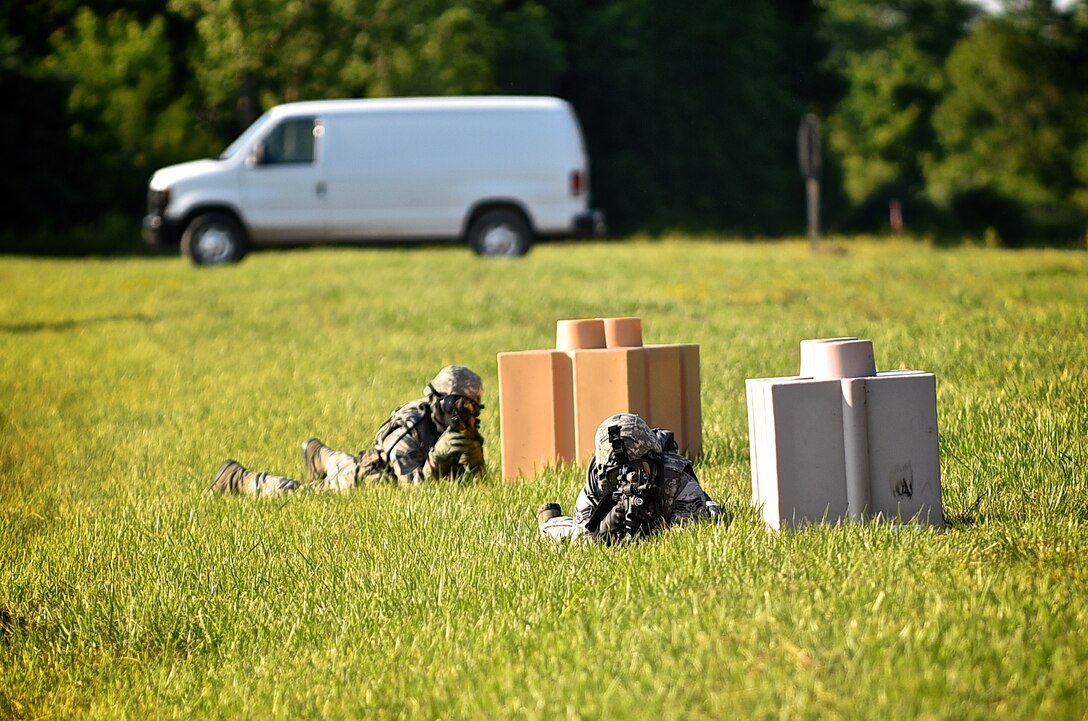 Two Airmen with the 932nd Airlift Wing Security Forces Squadron, acting as enemy combatants, fire special paint rounds at approaching SFS patrols during a training exercise near the Sparta Shooting Complex, Sparta Ill., June 9, 2015. Special protective gear was worn by all participants in the exercise.  The use of the paint rounds adds a heightened sense of realism to the training.  (U.S. Air Force photo/Tech. Sgt. Christopher Parr)