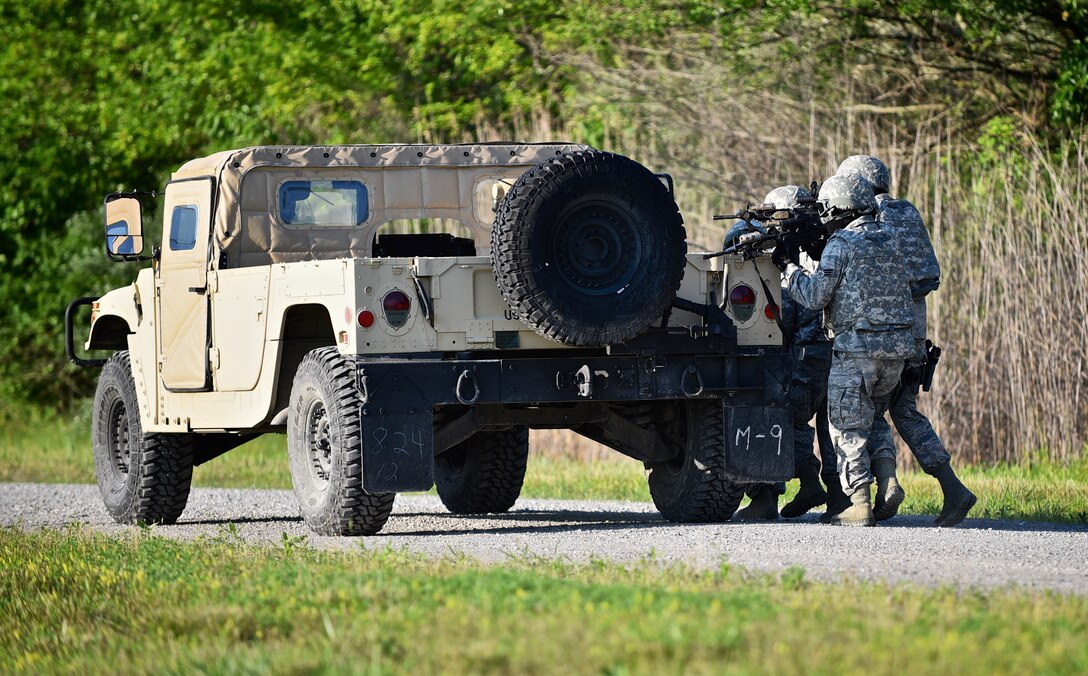 Members of the 932nd Airlift Wing Security Forces Squadron take cover behind their HUMVEE while returning fire during a training exercise near the Sparta Shooting Complex, Sparta Ill., June 9, 2015.  (U.S. Air Force photo/Tech. Sgt. Christopher Parr)