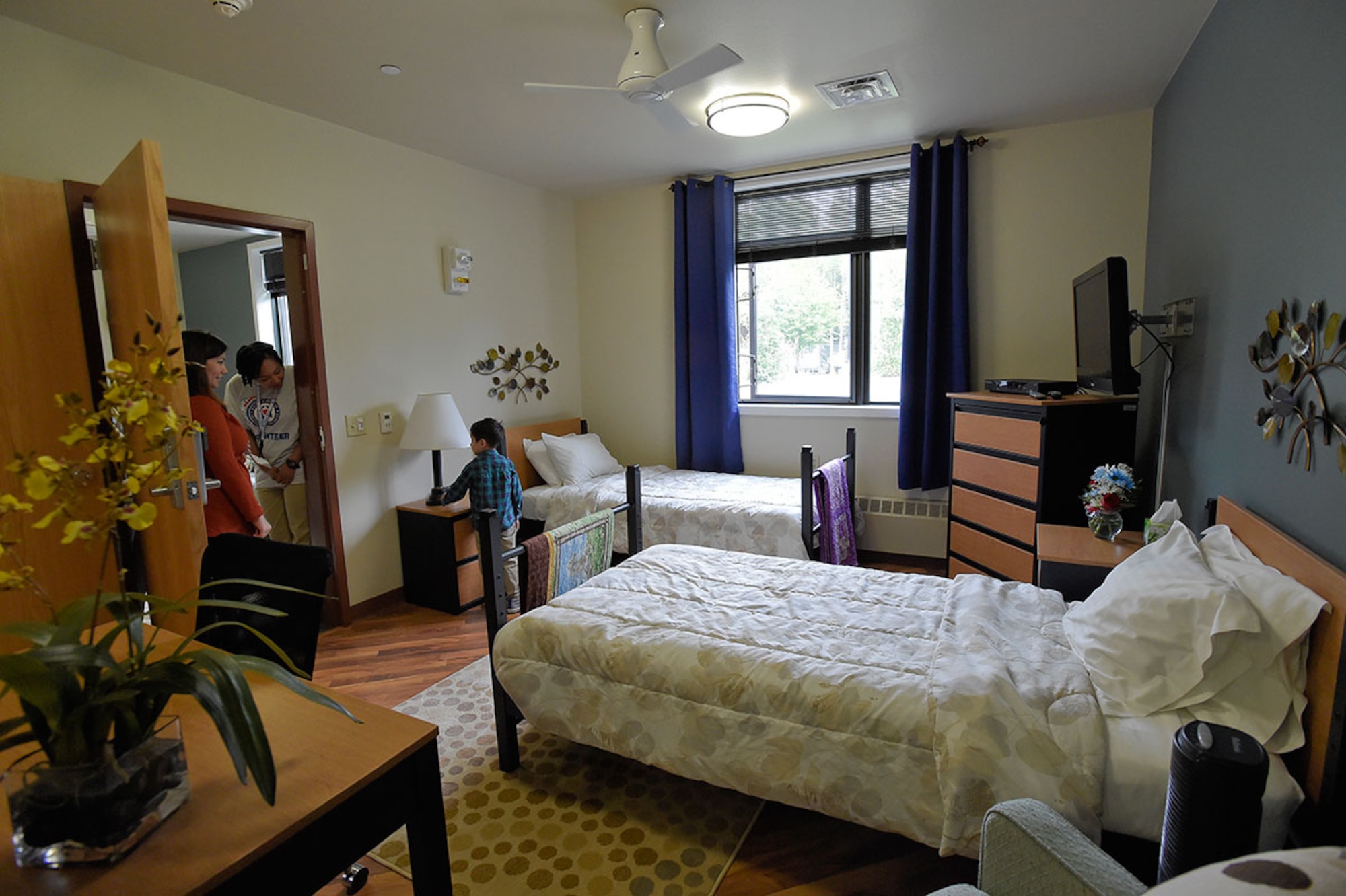 Visitors celebrating the dedication tour one of the of the newly renovated Fisher House of Alaska Annex rooms on JBER July 28. The Fisher House of Alaska is a lodging facility on JBER which provides a comfortable place for families to stay while service members or dependents are hospitalized. (U.S. Air Force photo/Alejandro Pena)