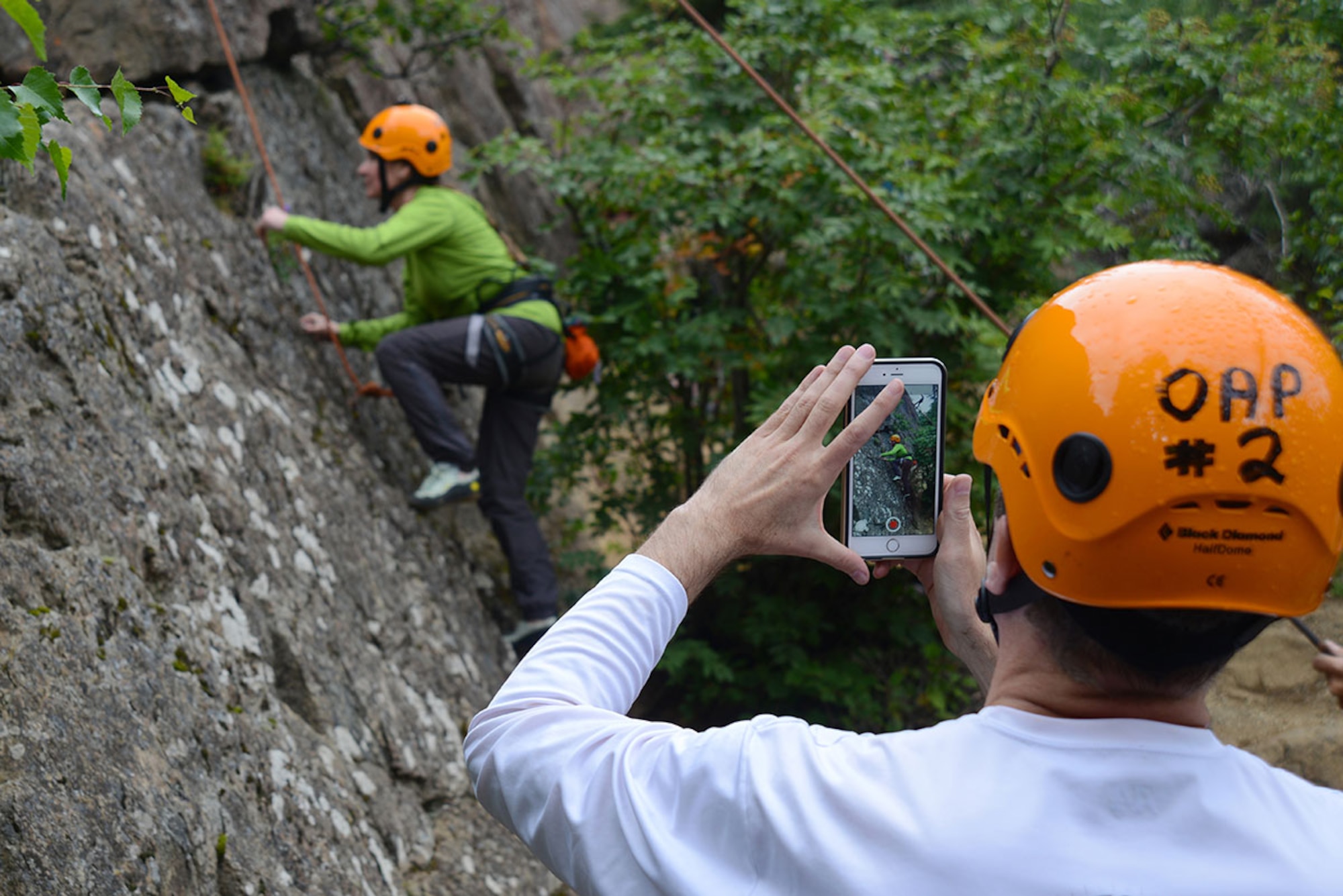 A student records veteran Lina Velar’s initial ascent up Boy Scout Rock in the McHugh Creek State Recreation Area of Chugach State Park July 9. The rock climbing trip is just one of the various fully-guided instructional outdoor adventure programs the JBER ORC offers which are are open to all Department of Defense identification card holders age eight and up. 