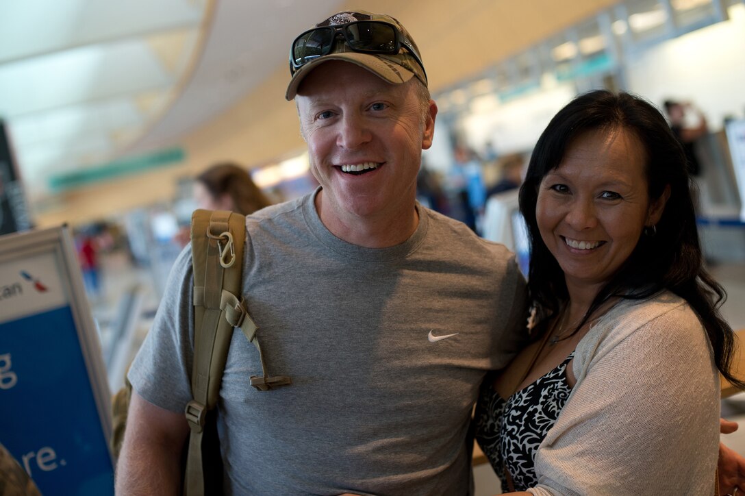 Senior Master Sgt. Dustin Mercer, 205th Engineering Installation Squadron electronic system NCO in charge, greets his wife, Tech Sgt. Trinh Mercer, 137th Force Support Squadron DEERS/RAPIDS representative, at Will Rogers World Airport, Aug. 2, 2015, after returning from a six-month deployment to Southwest Asia. The 205 EIS was providing support for the enhancement of their Command and Control, Communications, Computers, Intelligence, Surveillance and Reconnaissance (C4ISR) capabilities. (Air National Guard photo by Senior Airman Tyler K. Woodward/Released)