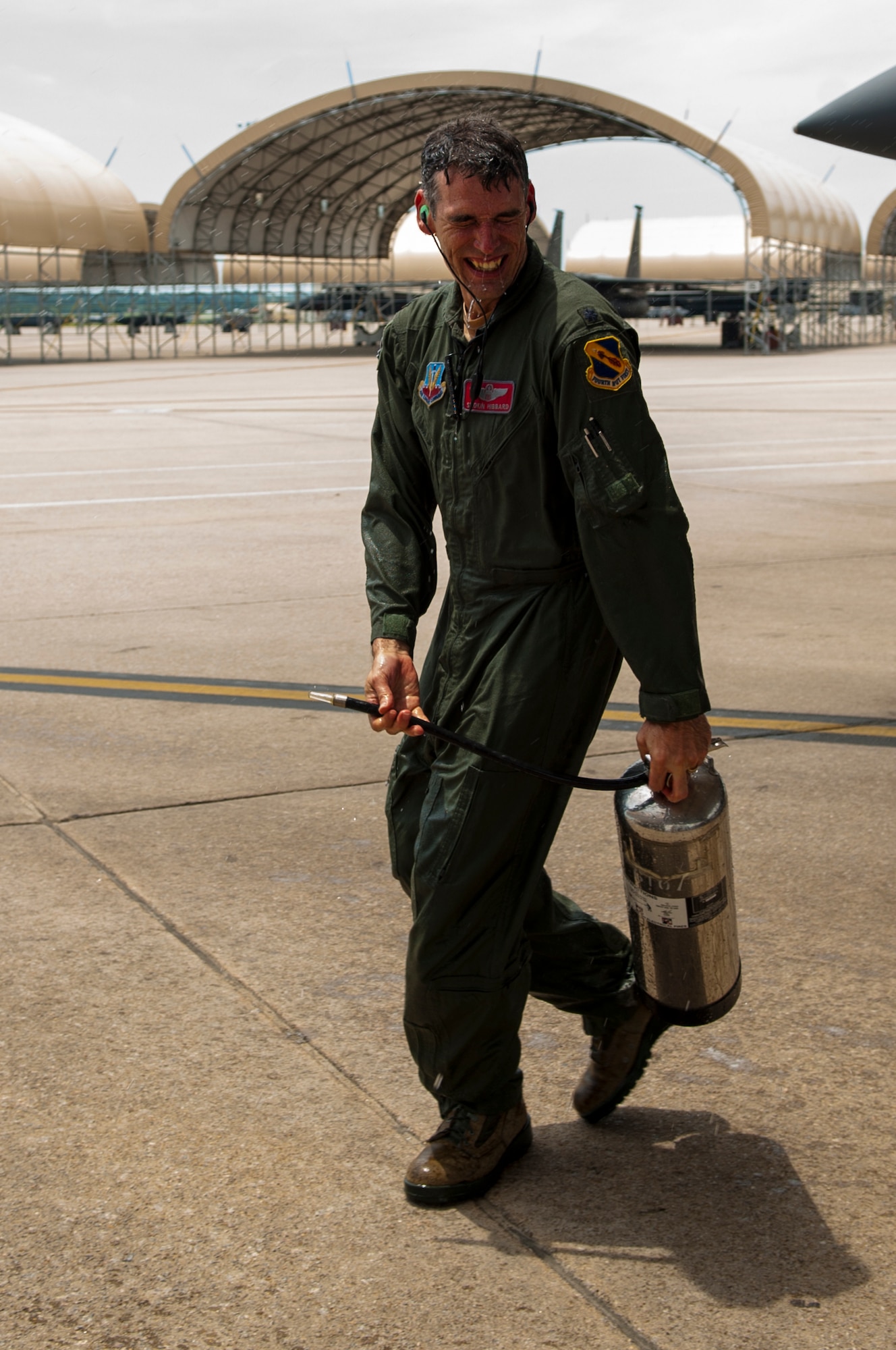 Lt. Col. Paul Hibbard, 333rd Fighter Squadron instructor pilot, laughs as he gets sprayed with water after a training flight where he reached 3,000hours flying the F-15E Strike Eagle, July 22, 2015, at Seymour Johnson Air Force Base, North Carolina. After the training flight, Hibbard was met by friends and family who hosed him down with water tanks to mark the career milestone. (U.S. Air Force photo/Airman Shawna L. Keyes)
