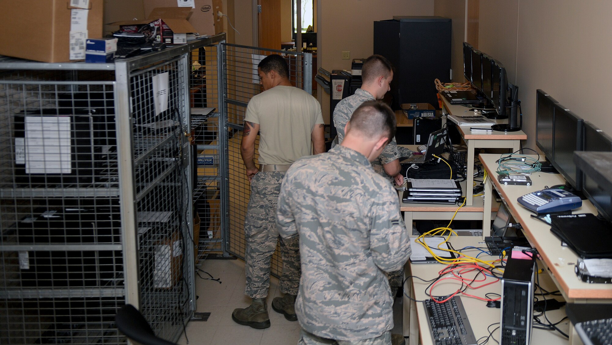 Airmen in the 22nd Communications Squadron communication focal point shop repair and replace damaged or unserviceable computer parts, Aug. 5, 2015, at McConnell Air Force Base, Kan. The 22nd CS personnel are the wing's computer systems and Local Area Network experts, managing several key computer systems, as well as hundreds of small computers through the base communications focal point. (U.S. Air Force photo by Senior Airman Colby L. Hardin)