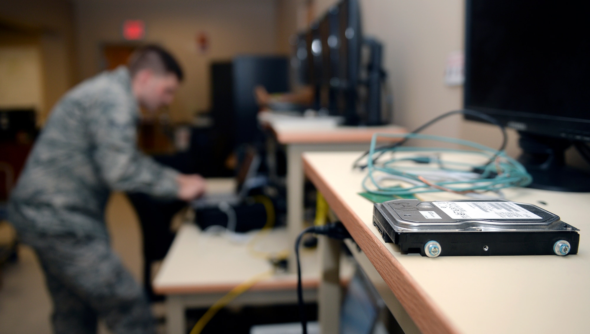A damaged computer hard drive sits on a work bench in the 22nd comfocal point shop before being repaired Aug. 5, 2015, at McConnell Air Force Base, Kan. The 22nd CS Airmen ensure Team McConnell’s computer, networks and telephones are serviceable to help keep the mission running smoothly. (U.S. Air Force photo by Senior Airman Colby L. Hardin) 