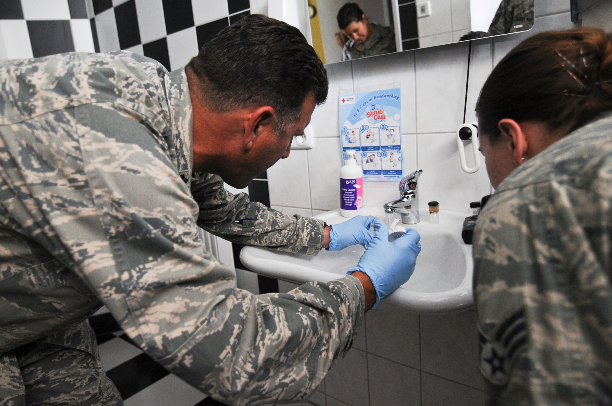 A picture of U.S. Air Force Lt. Col. Robert Desipio, the New Jersey Air National Guard's 177th Medical Group commander, collecting a water sample at an elementary school.