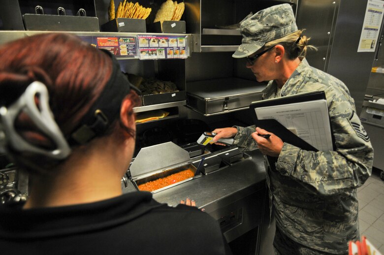 A picture of U.S. Air Force Master Sgt. Patricia Hughes, a public health technician with the New Jersey Air National Guard's 177th Medical Group, ensuring meat is of the proper temperature during an inspection.