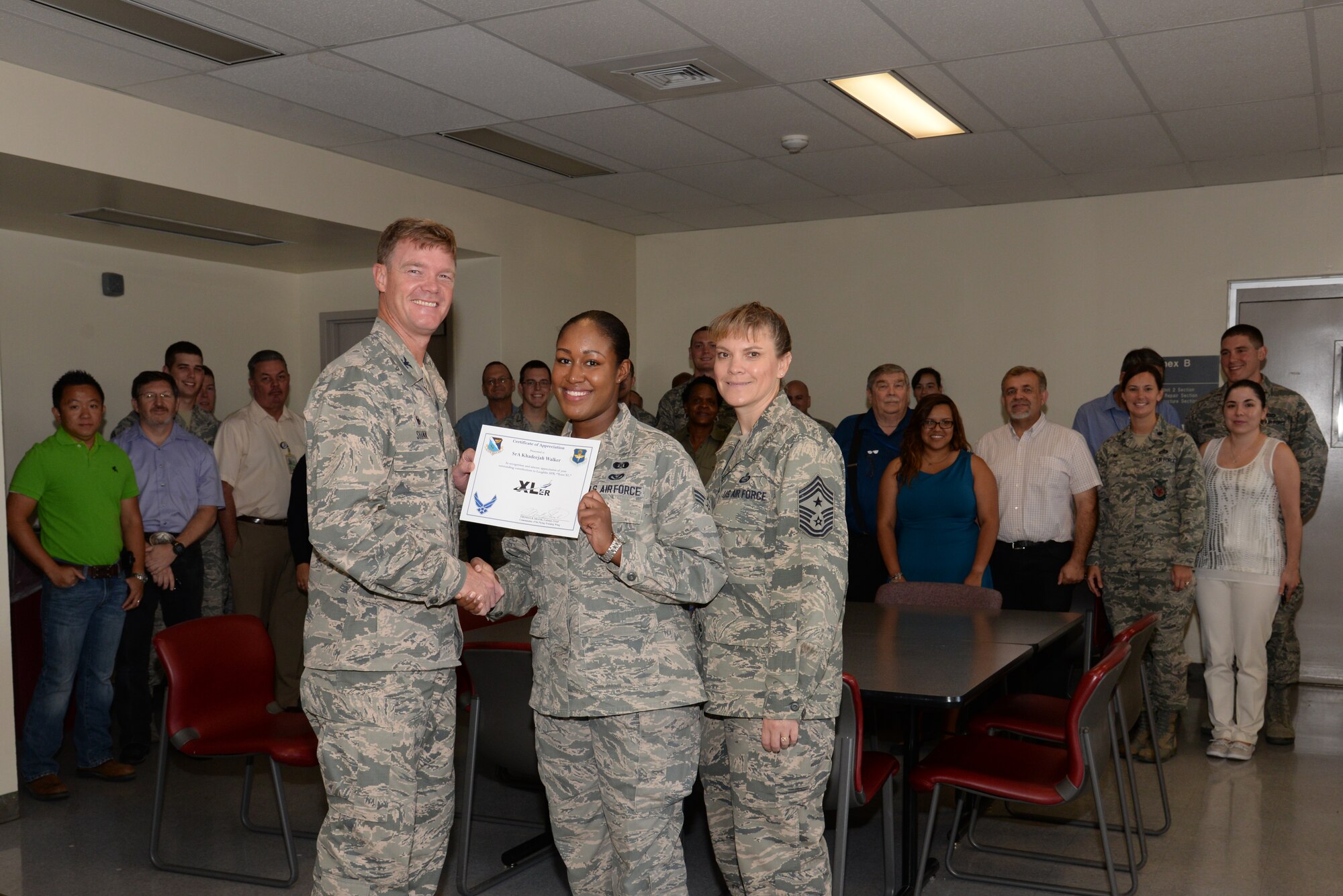 Senior Airman Khadeejah Walker, center, 47th Civil Engineer Squadron emergency management logistics apprentice, poses with Col. Thomas Shank, left, 47th Flying Training Wing commander, and Chief Master Sgt. Teresa Clapper, 47th FTW command chief, after accepting the “XLer of the Week” award, here, July 30, 2015. The “XLer” is a weekly award chosen by wing leadership and is presented to those who consistently make outstanding contributions to their unit and Laughlin. (U.S. Air Force photo by Airman 1st Class Brandon May)