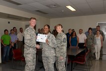 Senior Airman Khadeejah Walker, center, 47th Civil Engineer Squadron emergency management logistics apprentice, poses with Col. Thomas Shank, left, 47th Flying Training Wing commander, and Chief Master Sgt. Teresa Clapper, 47th FTW command chief, after accepting the “XLer of the Week” award, here, July 30, 2015. The “XLer” is a weekly award chosen by wing leadership and is presented to those who consistently make outstanding contributions to their unit and Laughlin. (U.S. Air Force photo by Airman 1st Class Brandon May)