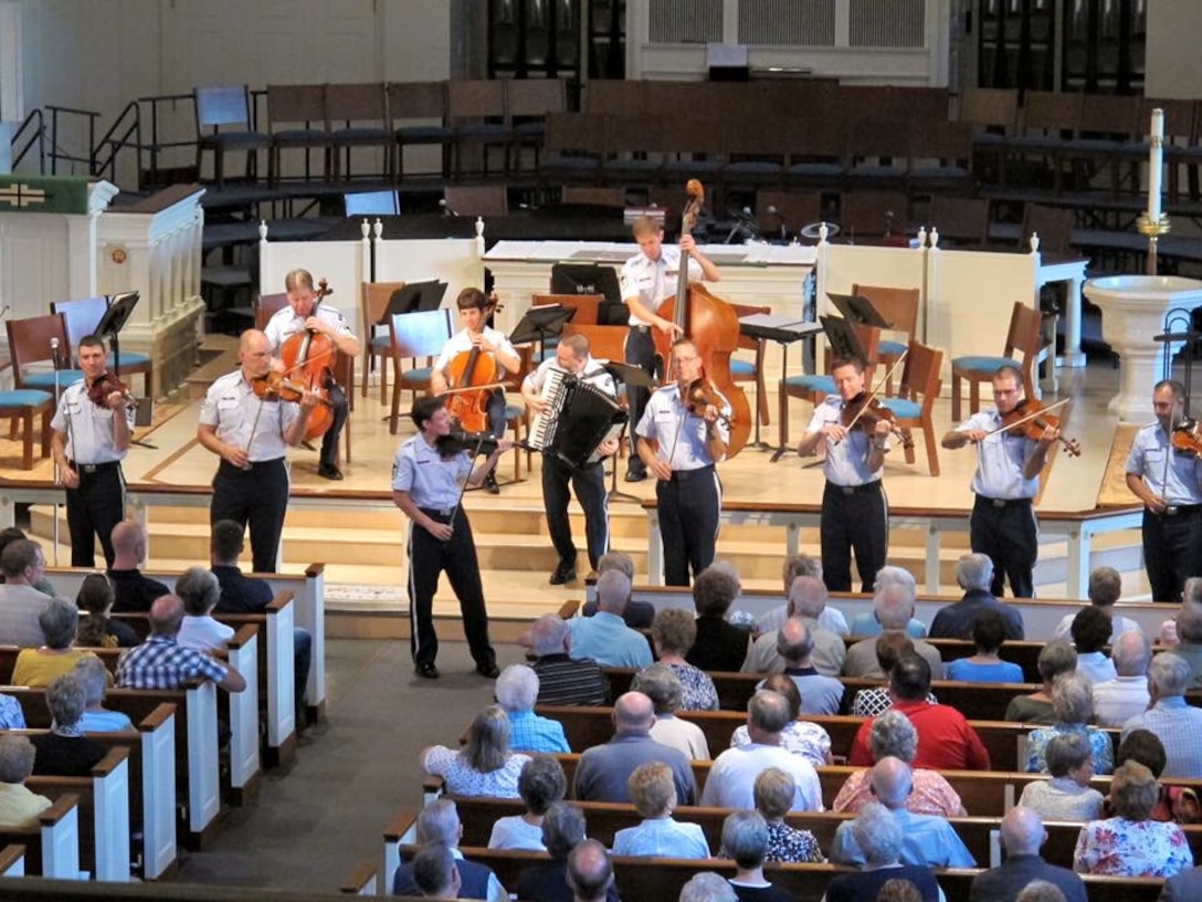 Chief Master Sergeant Deb Volker leads the Air Force Strings in a strolling show at Trinity Lutheran Church in Lansdale, Pennsylvania.  The concert was part of their 7-day community relations tour of the Northeast. (U.S. Air Force Photo/released)
