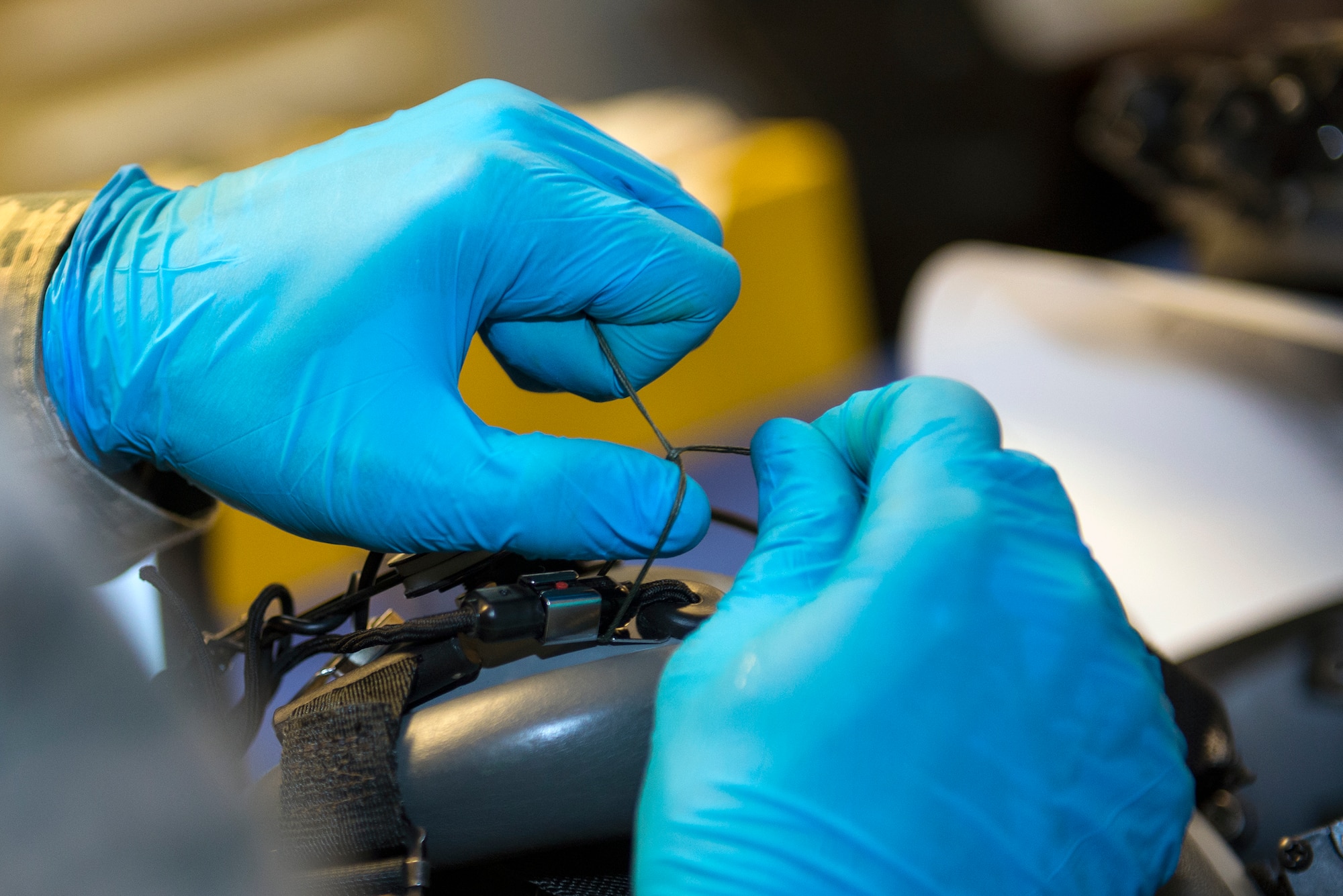 U.S. Air Force Airman 1st Class Justin Smith, 347th Operations Support Squadron aircrew flight equipment technician, places a safety tie cord plug into a HGU-55/P helmet bracket Aug. 5, 2015, at Moody Air Force Base, Ga. The tie is used to uphold and support the pilot’s communication system within the helmet. (U.S. Air Force photo by Airman Greg Nash/Released)