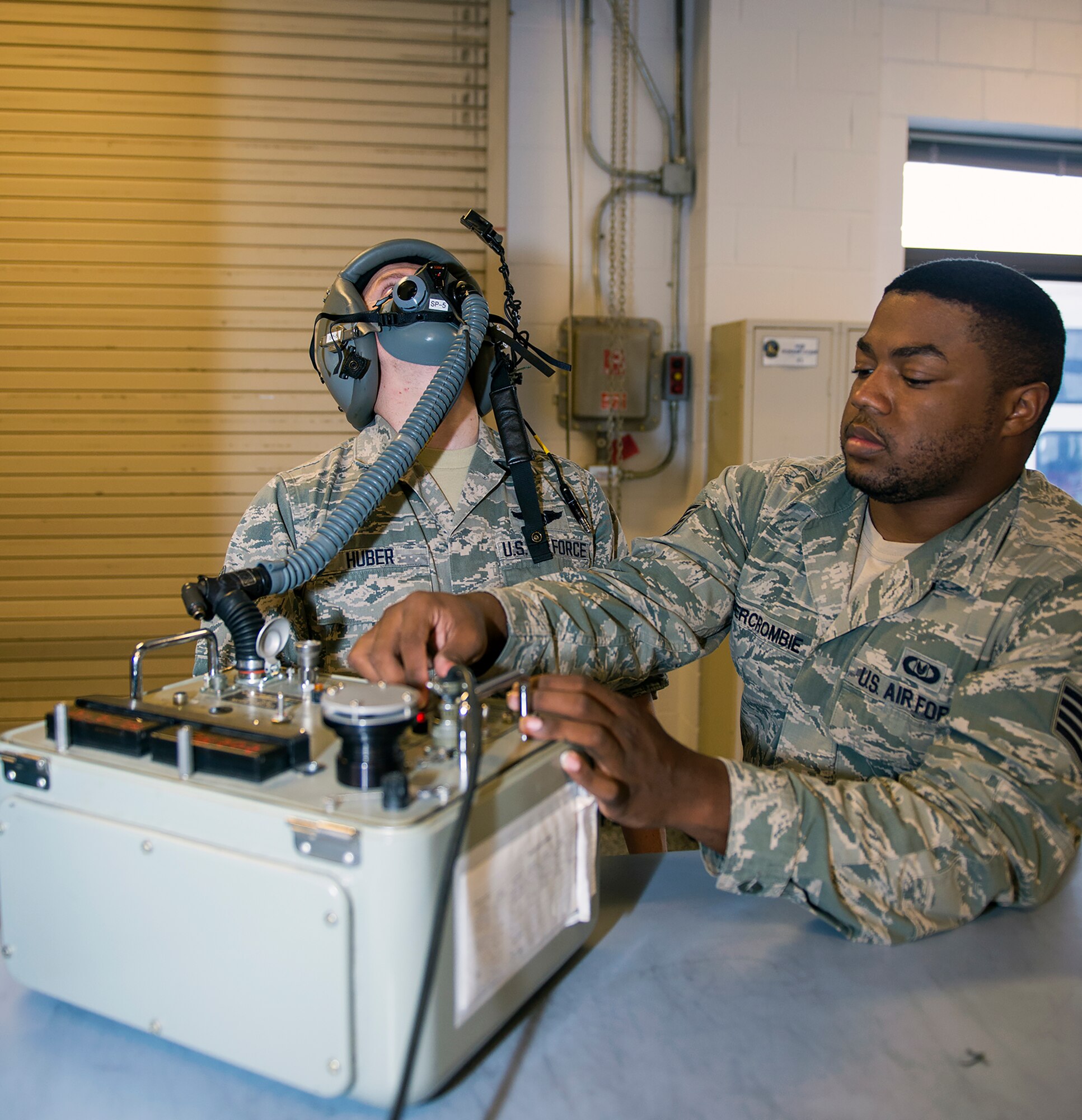 U.S. Air Force Senior Airman Charles Huber, 71st Rescue Squadron loadmaster, motions his head while participating in a Scot Tester Inspection conducted by Staff Sgt. Brandon Abercrombie, 347th Operations Support Squadron aircrew flight equipment assistant NCO in charge, Aug. 5, 2015, at Moody Air Force Base, Ga. The test inspects the helmet for leakage and proper fitting. (U.S. Air Force photo by Airman Greg Nash/Released) 