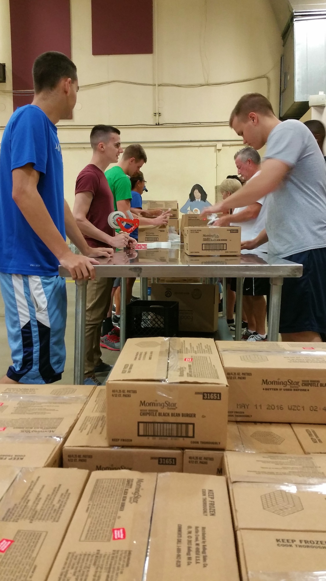 Team Scott volunteers work to pack black bean burgers to be sent out to local food banks from the St. Louis Area Foodbank, Bridgeton, Mo., July 25, 2015. Volunteering for food bank efforts can be through food drives and coming to help pack food on a Saturday. According to the Foodbank, the need is there year round from the people they assist. (U.S. Air Force photo by Airman 1st Class Erica Holbert-Siebert)