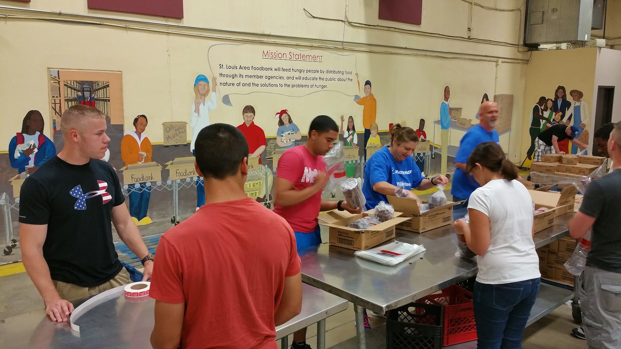 Team Scott volunteers work to pack black bean burgers to be sent out to local food banks from the St. Louis Area Foodbank, Bridgeton, Mo., July 25, 2015. Volunteering for food bank efforts can be through food drives and coming to help pack food on a Saturday. According to the Foodbank, the need is there year round from the people they assist. (U.S. Air Force photo by Airman 1st Class Erica Holbert-Siebert)