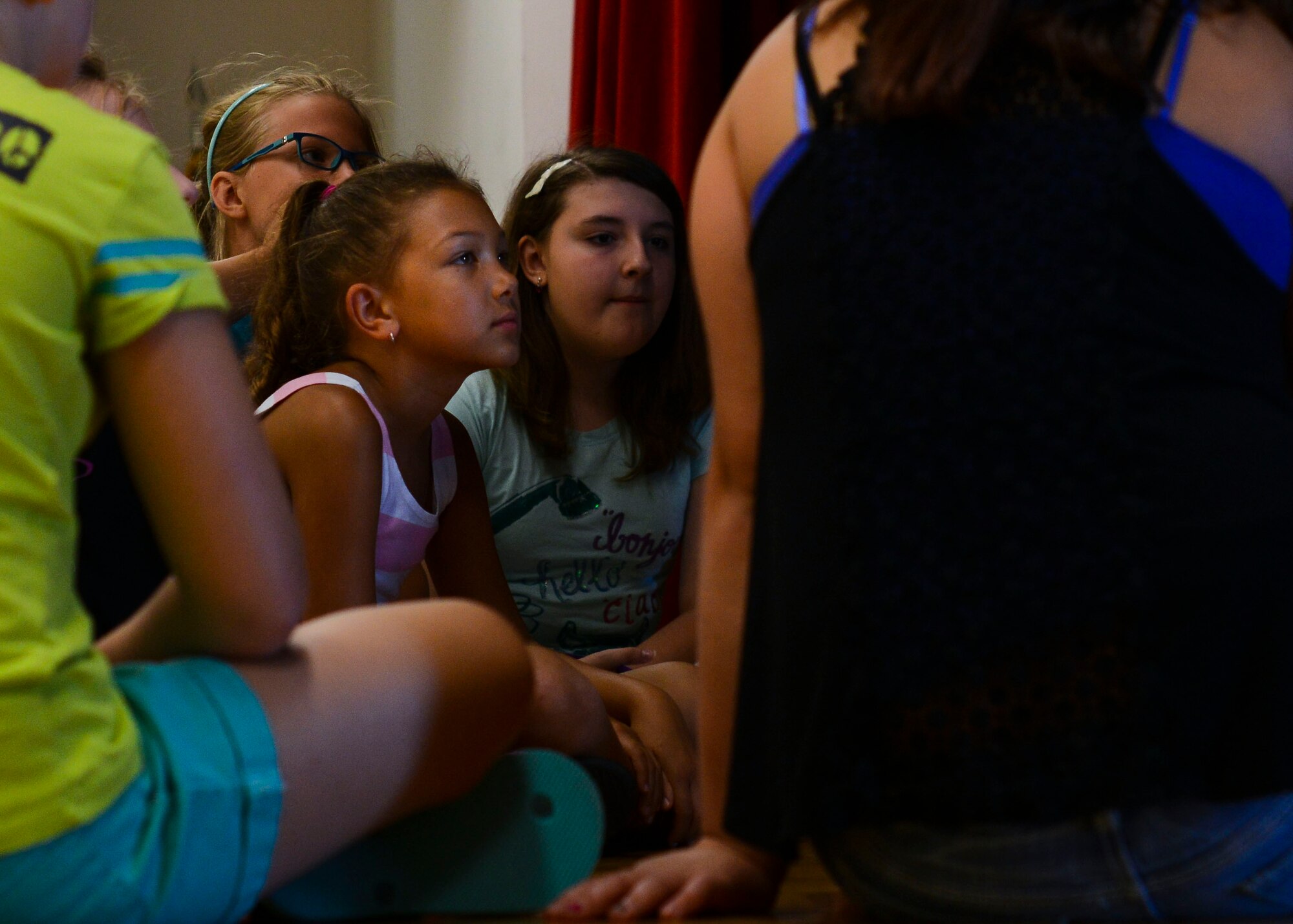 Team Aviano children listen to instruction from their “Aladdin” musical director during rehearsal, Aug. 4, 2015, at Aviano Air Base, Italy. The children will practice every day until show time at 5 p.m. on Aug. 8 in the community center on Area 1. (U.S. Air Force photo by Senior Airman Austin Harvill/Released)