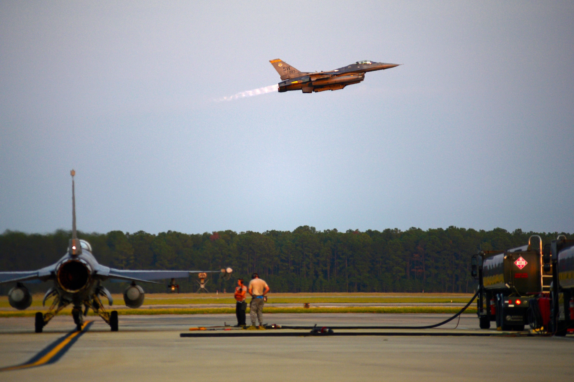 An F-16CM Fighting Falcon assigned to the 20th Fighter Wing flies over the runway at Shaw Air Force Base, S.C., July 31, 2015. Before conducting night flying operations, Airmen had to perform hot pit refueling which enables aircraft to be refueled rapidly without having to turn off the engine. (U.S. Air Force photo by Senior Airman Jensen Stidham/Released) 