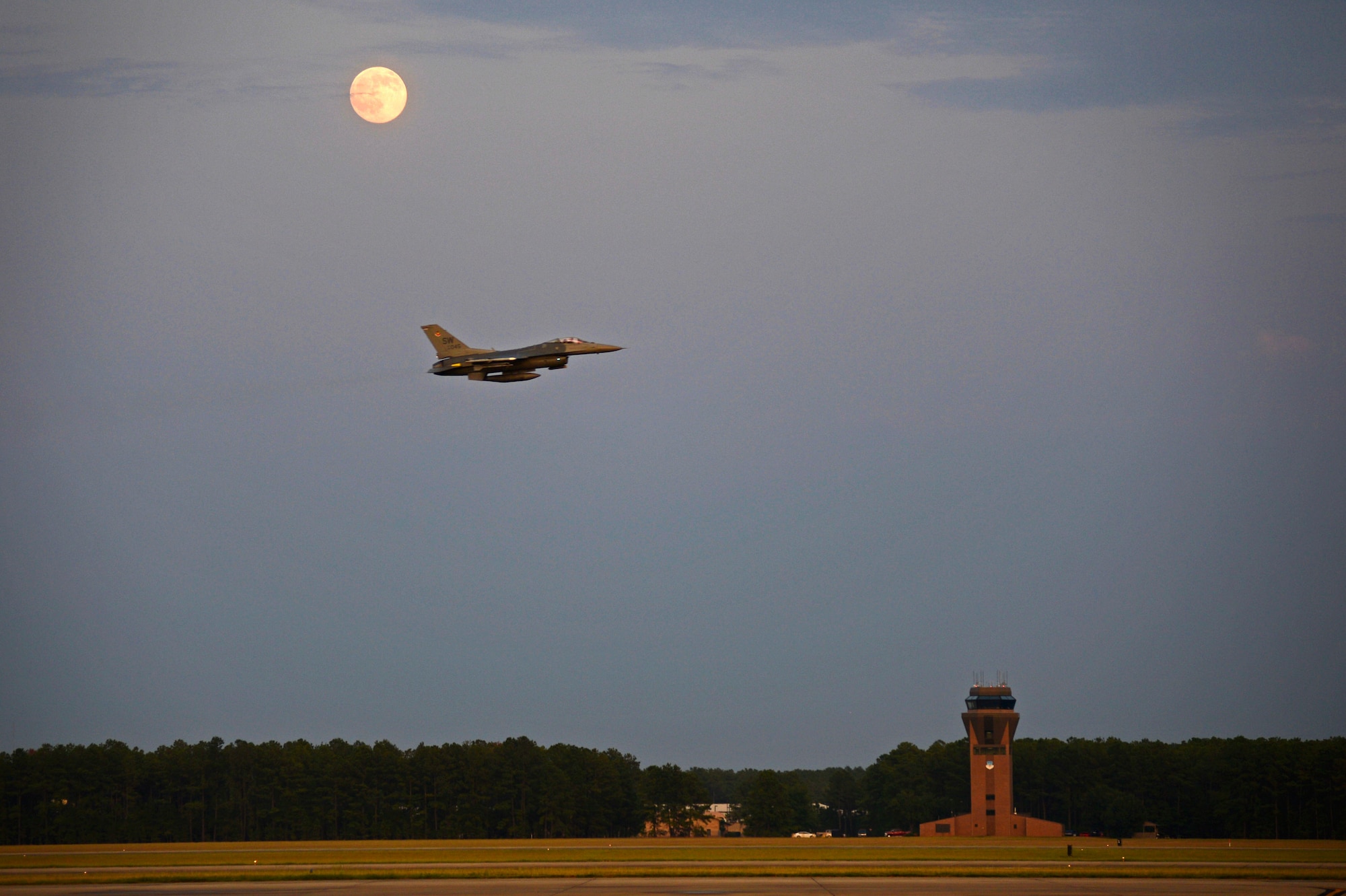 An F-16CM Fighting Falcon assigned to the 20th Fighter Wing flies over the runway at Shaw Air Force Base, S.C., July 31, 2015. The 20th Fighter Wing pilots flew night sorties to practice using night vision equipment and perform tactics that are critical to survivability during combat situations. (U.S. Air Force photo by Senior Airman Jensen Stidham/Released) 
