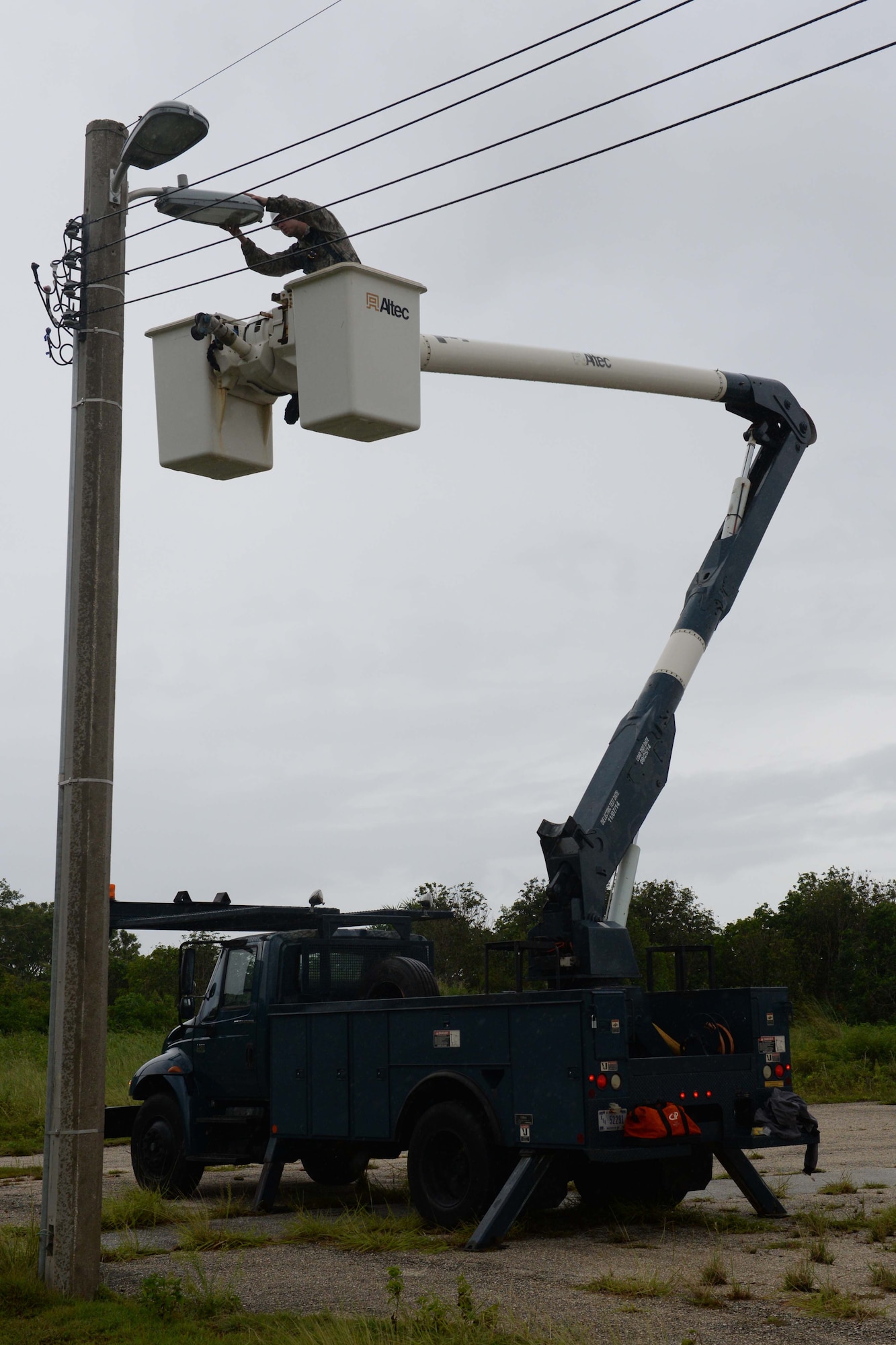 Airman Dakota Bennett, 36th Civil Engineer Squadron electrical systems specialist, repairs a damaged street light Aug. 5, 2015, at Andersen Air Force Base, Guam. Base electricians are responsible for maintaining several different distribution systems that include high voltage, airfield lighting, lightning protection, fire alarm and interior electrical. (U.S. Air Force photo by Senior Airman Joshua Smoot/Released)