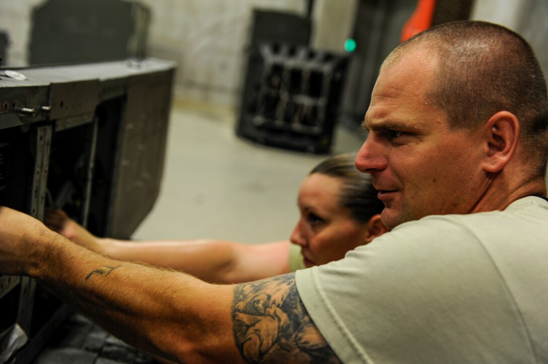 U.S. Air Force Staff Sgt. Thomas Lewellen, 18th Component Maintenance Squadron aircraft fuel systems craftsman, and U.S. Air Force Senior Airman Elizabeth Melton, 18th CMS fuel systems journeyman, repair an aircraft fuel pylon on Kadena Air Base, Japan, Aug. 4, 2015. Lewellen has worked on aircraft for his nine years in the Air Force. Considered to be the most knowledgeable person in his shop concerning his work with fuels and F-15s, he finds the time to combine performing his own job as well as supervising and mentoring Airmen. (U.S. Air Force photo by Airman 1st Class Lynette Rolen)