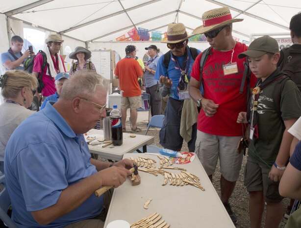 Mikah Ricafrente, a Boy Scout with Troop 77, and his father, Master Sgt. Nephtali D. Ricafrente, watch as a world scout volunteer assembles wooden knives in the Boy Scouts of America tent at the 23rd World Scout Jamboree in Kirara-hama, Yamaguchi, Japan, August 1, 2015. This is Japan’s second time hosting the World Scout Jamboree, which occurs every four years. The U.S., Mexico and Canada are co-hosting the 24th World Scout Jamboree in 2019, in West Virginia.
